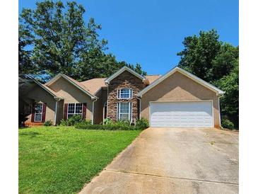 Charming single-Gathering home with a manicured lawn, stone accents, and a two-car garage in a quiet neighborhood at 625 Chaseridge Drive Dr, Mcdonough, GA 30253