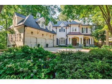 Stunning brick home with manicured landscaping, three car garage, and covered front porch at 1412 Lanier Ne Mnr, Atlanta, GA 30319