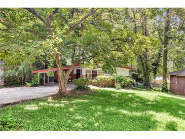 Charming single-story home with a covered carport and beautiful mature trees at 2991 Monterey Drive Dr, Decatur, GA 30032