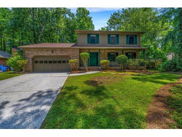 Charming two-story home with brick facade, lush lawn, and mature trees offering shade and curb appeal at 2775 Doaks Run Ct, Tucker, GA 30084