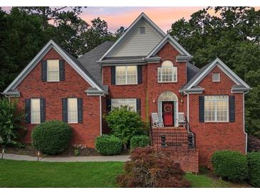 Charming two-story brick home with a well-manicured lawn and inviting front porch at 10119 Azalea Dr, Covington, GA 30014