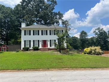 Charming two-story home with a well-manicured lawn, bright red door, and classic black shutters at 1725 Spindle Top Sw Ct, Lilburn, GA 30047