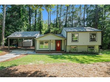 Charming home featuring a covered carport, a red front door, and a lush front yard at 3195 Newcastle Way, Snellville, GA 30039