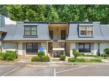 Charming townhouse with well-maintained landscaping, accessible parking, and covered entry, showcasing a cozy residential appeal at 68 La Rue Nw Pl, Atlanta, GA 30327