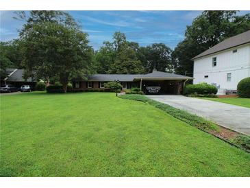 Charming single-story brick home featuring lush landscaping and a covered parking area at 742 Starlight Ne Ct, Sandy Springs, GA 30342