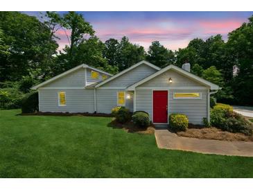 Charming single-story home with a well-maintained lawn and a vibrant red front door at 1480 Bettis Tribble Gap Rd, Cumming, GA 30040