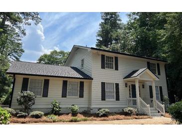 Charming two-story home featuring a classic white facade, black shutters, and a well-manicured front yard at 1789 Springhouse Ct, Lawrenceville, GA 30043