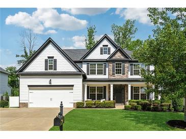 Charming two-story home featuring stone accents, a manicured lawn, and a two-car garage at 236 Lakestone Pkwy, Woodstock, GA 30188