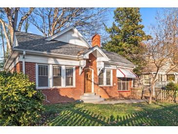 Charming brick home featuring a well-maintained lawn, beautiful landscaping, and a welcoming front entrance at 1015 Deckner Sw Ave, Atlanta, GA 30310
