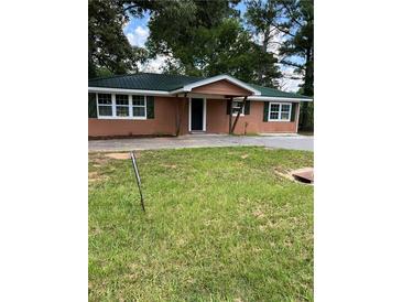 Charming single story home with a green metal roof and inviting front porch at 10591 Flat Shoals Rd Rd, Covington, GA 30016