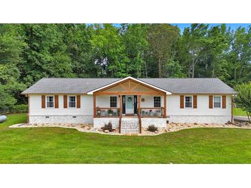 Charming one-story home with a welcoming front porch and a well-manicured lawn and beautiful landscape at 146 Henderson Farm Ln, Canton, GA 30115