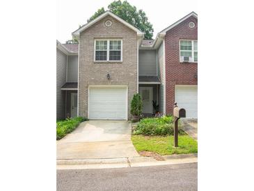 Charming townhome featuring a one-car garage and well-maintained landscaping at 5590 Stonewood Court Ct, Norcross, GA 30093