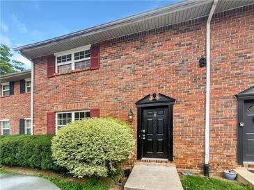 Charming brick townhome featuring a well-manicured lawn and classic architectural details at 6354 Shannon Pkwy # 8B, Union City, GA 30291