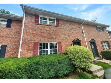Brick townhouse exterior with red shutters and green landscaping at 6354 Shannon Pkwy # 8B, Union City, GA 30291