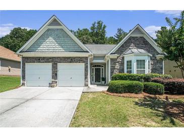 Charming single-story home featuring a two-car garage, stone accents, and well-manicured landscaping at 1856 Temple Park Dr, Loganville, GA 30052