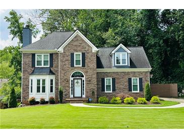 Charming brick home with lush lawn and well-maintained landscaping at 735 Jamie Ne Way, Woodstock, GA 30188