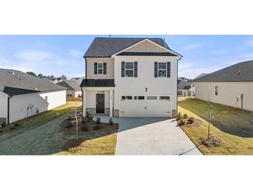 Beautiful two-story home featuring a two-car garage, manicured lawn, and classic architectural details at 11903 Aukerman Way, Hampton, GA 30228