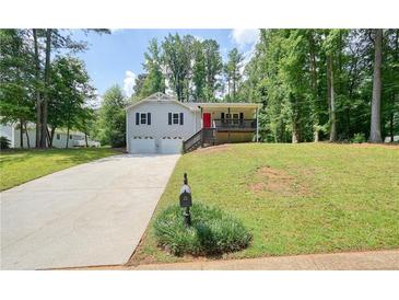 Charming two-story home with a well-manicured front lawn, driveway, and a red front door at 276 Indian Creek Dr, Powder Springs, GA 30127