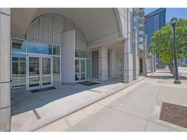 Modern building entrance featuring glass doors, concrete columns, and clear signage for easy access at 361 17Th St # 1121, Atlanta, GA 30363