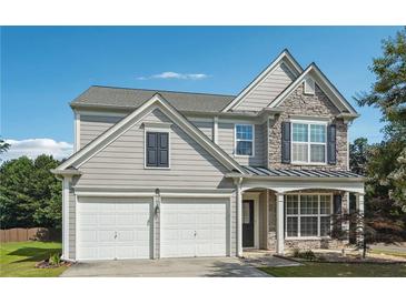 Beautiful two-story home featuring stone accents, a two-car garage, and a well-maintained lawn at 8965 Friarbridge Dr, Suwanee, GA 30024