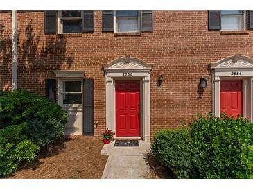 Charming townhome with a striking red front door and well-maintained landscaping at 2886 Webb Bridge Rd, Alpharetta, GA 30009
