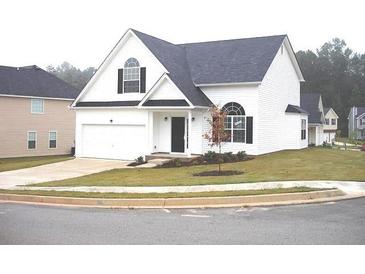 Charming two-story home featuring a manicured lawn and attached two car garage, offering both curb appeal and convenience at 4232 Kensington Cv, Atlanta, GA 30349