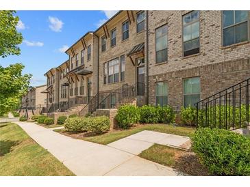 Beautiful brick townhomes with manicured landscaping and inviting walkways at 613 Harrington Hls, Decatur, GA 30032