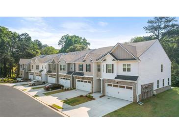 Charming townhomes with two-car garages, neutral colors, and tasteful brick and siding accents in a well-maintained community at 1317 Aura Ln, Lawrenceville, GA 30045