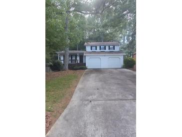 Charming two-story home featuring a two-car garage and inviting front porch in a wooded setting at 2857 Mountbery Dr, Snellville, GA 30039