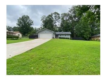 Well maintained home on large lot with a sprawling green lawn and an extended concrete driveway at 284 Regal Dr, Lawrenceville, GA 30046