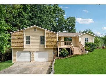Charming two-story home with a two-car garage, a welcoming front porch, and a beautifully landscaped front yard at 3753 Eli Dr, Snellville, GA 30039