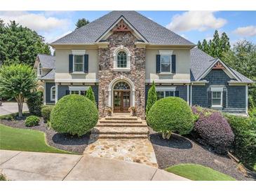 Stunning stone and stucco home with manicured landscaping, a welcoming entrance, and a beautiful stone walkway at 3090 Creek Tree Lane, Cumming, GA 30041