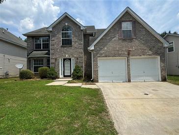 Charming two-story brick home with a well-manicured lawn, a two-car garage and a welcoming front entrance at 3850 Micah Ln, Ellenwood, GA 30294