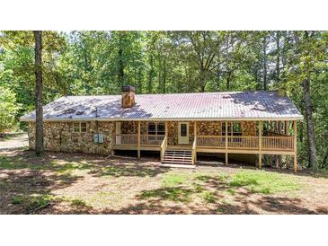 Charming ranch-style home with stone facade and a spacious wooden deck, nestled among lush trees at 257 Martin Ln, Canton, GA 30114