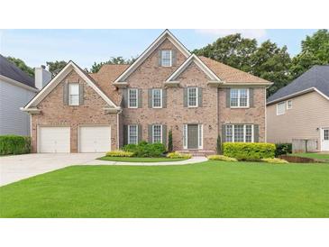 Charming brick home featuring a well-manicured lawn and a two-car garage at 8073 Ridge Vly, Woodstock, GA 30189
