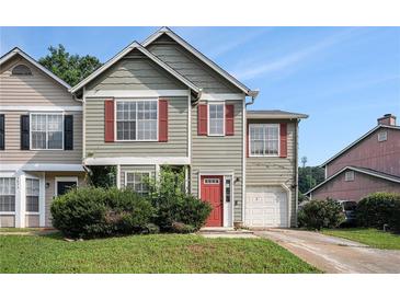 Inviting two-story townhouse featuring red shutters, a red door, and a one-car garage at 3835 Conley Downs Dr, Decatur, GA 30034