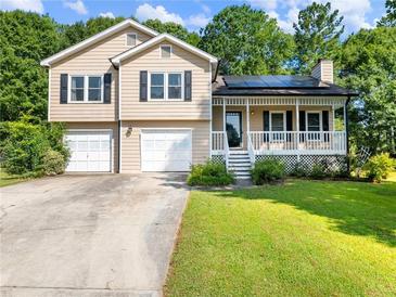 Charming home with a front porch, well-maintained lawn and two-car garage at 443 Rhett Dr, Loganville, GA 30052