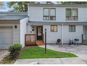 Charming two-story townhome featuring a welcoming front porch, siding, and well-manicured lawn at 102 Oak Pl, Villa Rica, GA 30180