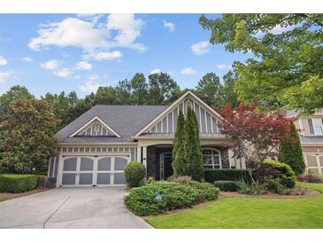 Charming home featuring a well-manicured lawn, a two-car garage, and beautiful landscaping at 308 Shade Tree Cir, Woodstock, GA 30188