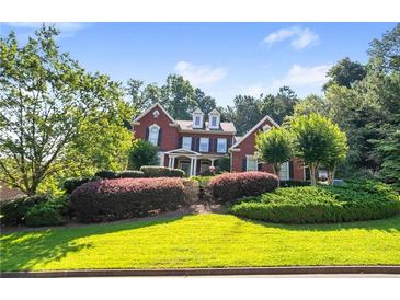 Charming two-story brick home with manicured landscaping and a welcoming front yard at 5410 Cottage Farm Rd, Alpharetta, GA 30022