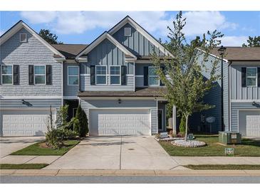 Charming townhome with a blue exterior, two-car garage, and well-manicured front yard at 7086 Gladstone Cir, Lithonia, GA 30038