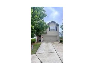 Charming two-story home featuring a spacious driveway and an attached garage for convenient parking at 1403 Comet Ives Ln, Lawrenceville, GA 30045