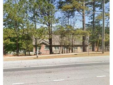Brick building with multiple windows partially obscured by trees at 3428 Mount Zion Rd, Stockbridge, GA 30281