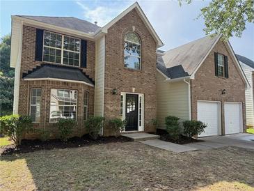 Charming two-story brick home with well-manicured lawn and attached two-car garage at 4189 Post Oak Grv, Atlanta, GA 30349