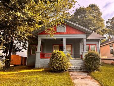 Charming two-story home with a cozy front porch and landscaped front yard, perfect for relaxing outdoors at 1373 Lucile Sw Ave, Atlanta, GA 30310