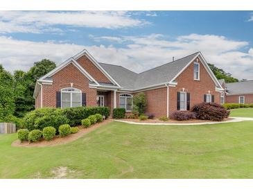 Charming brick home with manicured lawn, complemented by verdant shrubbery and mulch beds at 995 Lewis Ridge Cir, Lawrenceville, GA 30045