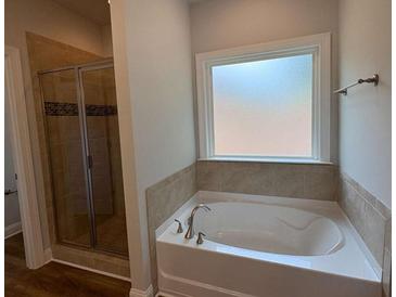 Modern bathroom features a soaking tub with tile surround and separate glass shower at 5311 Tuscany Dr, Douglasville, GA 30135