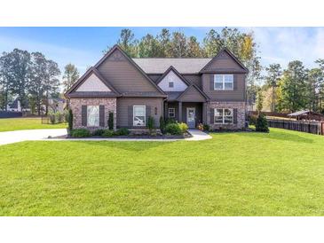 Beautiful two-story home featuring a well-manicured lawn and complementary brick and siding accents at 125 Atkins Ln, Fayetteville, GA 30215