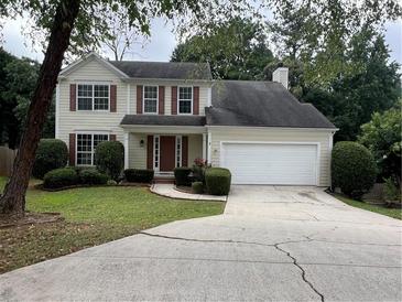 Charming two-story home with manicured lawn and attached two car garage at 11800 Carriage Park Ln, Johns Creek, GA 30097