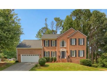 Charming two-story brick home with manicured lawn and attached two car garage at 140 Heritage Ct, Fayetteville, GA 30214